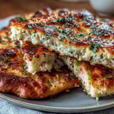 Warm The Best Easy Garlic Naan Bread brushed with melted butter and garlic, resting on a wooden board.