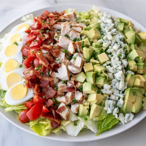 Freshly prepared Cobb salad featuring vibrant tomatoes and blue cheese, perfect for a light lunch.