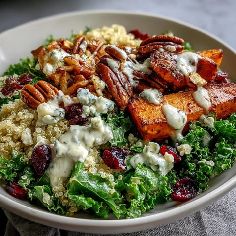 Harvest Kale Quinoa Bowl with roasted sweet potatoes, crunchy pecans, and tangy blue cheese, drizzled with lemon tahini dressing.  