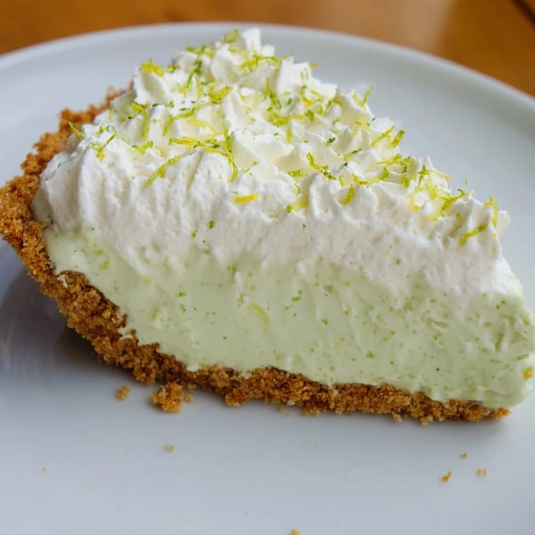 A slice of delicious key lime pie, showcasing the sweet-tart filling and refreshing flavors.