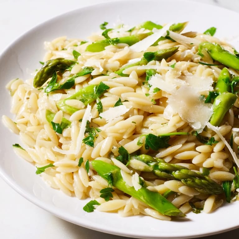 Enjoy this vibrant vegetarian Asparagus Lemon Orzo Salad with arugula and herbs, a perfect chilled pasta salad for sunny picnics.