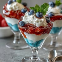Red, white, and blue layered Jello cups in clear glasses, perfect for patriotic celebrations.